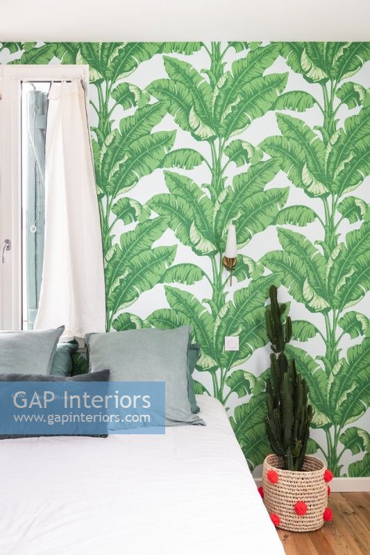 Tropical wallpaper on wall of modern bedroom 
