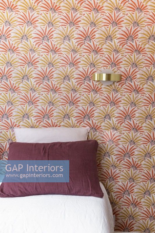 Patterned red and yellow wallpaper in modern bedroom 