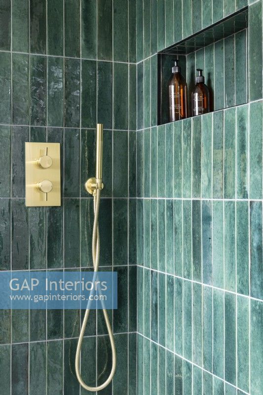 Contemporary modern shower with vertical green tiles and gold, brass taps