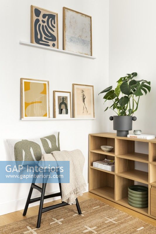 Scandinavian minimal contemporary living room, black and oak colour furniture, open shelves and wall art