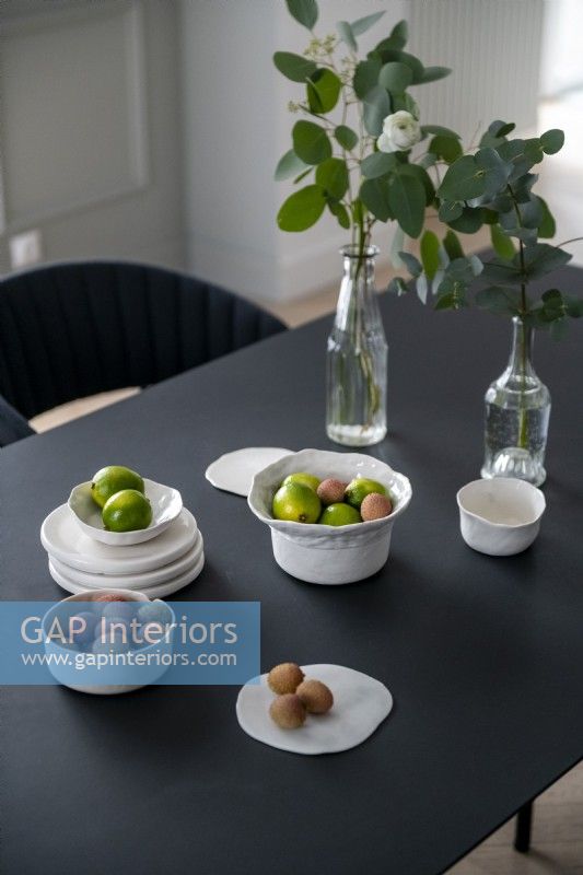 Bowls of fruit on modern black dining table

