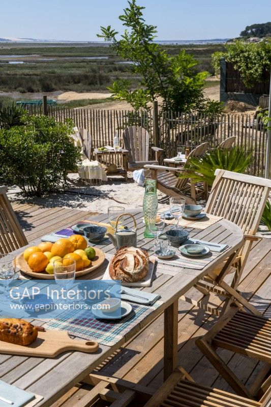 Outdoor dining table laid for lunch with coastal views in summer 