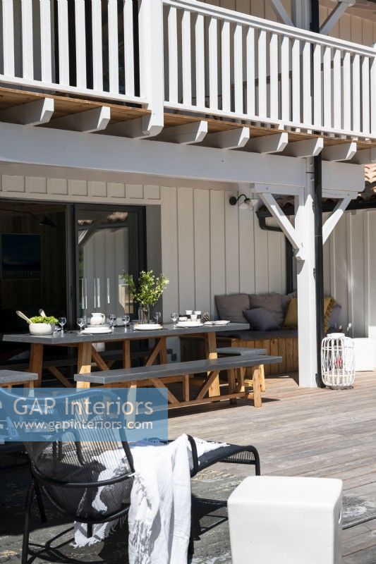 Outdoor dining area on decking next to country house