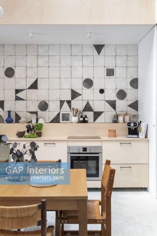 Modern kitchen-diner with geometric shapes on splashback tiling