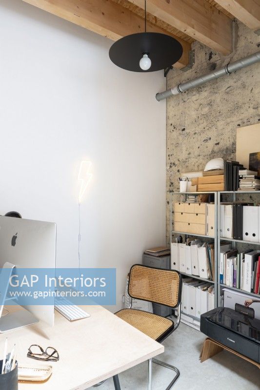 Modern home office with bare plaster wall and exposed pipework