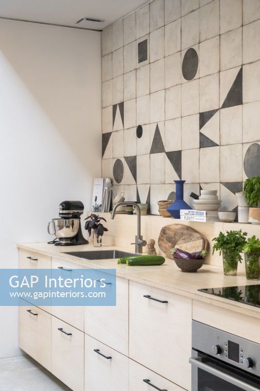 Modern kitchen with geometric shapes on splashback tiling