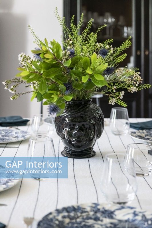 Flower and foliage arrangement on country dining table - detail