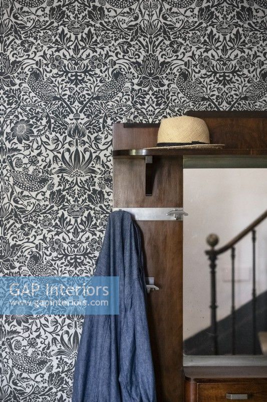 Coat and hat stand in hallway with decorative wallpaper - detail