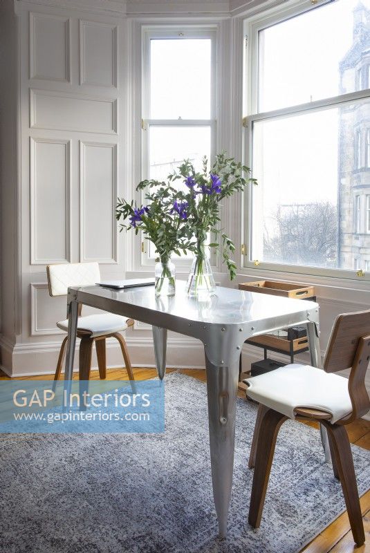 Small metal dining table in bay window