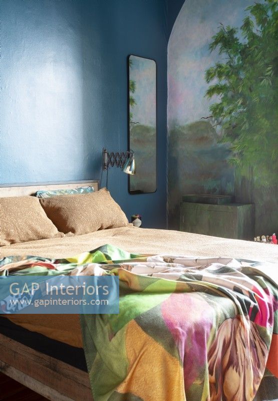 Colourful modern bedroom with mural painted on walls