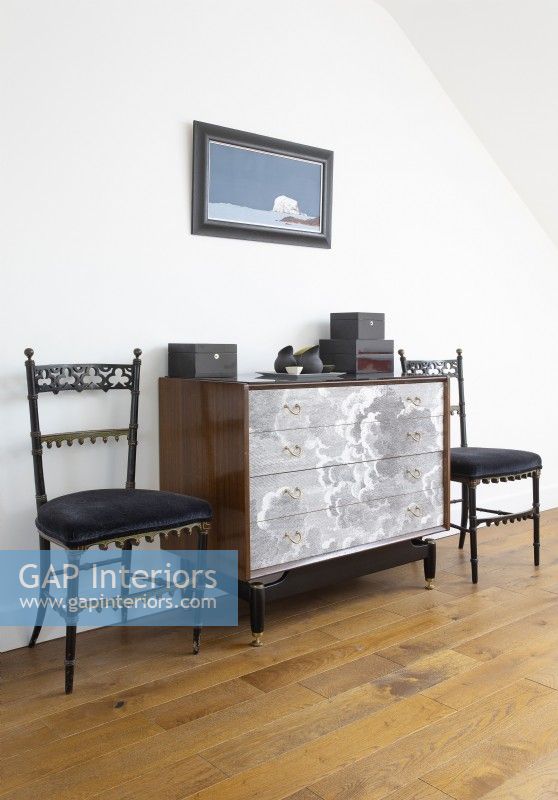 Antique chairs and vintage chest of drawers in modern bedroom