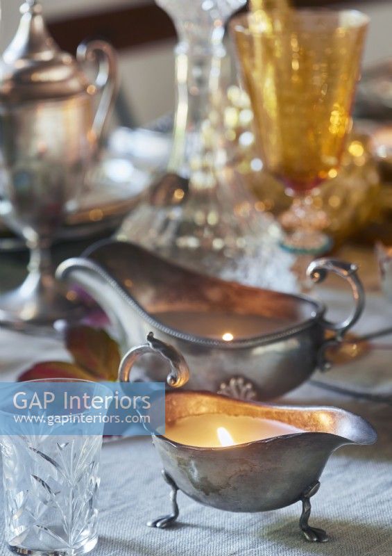 Silver gravy boat candle holder on dining table