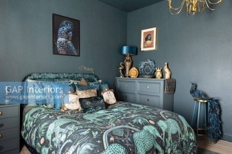 Teal coloured bedroom with elephant patterned bed linen and painted furniture