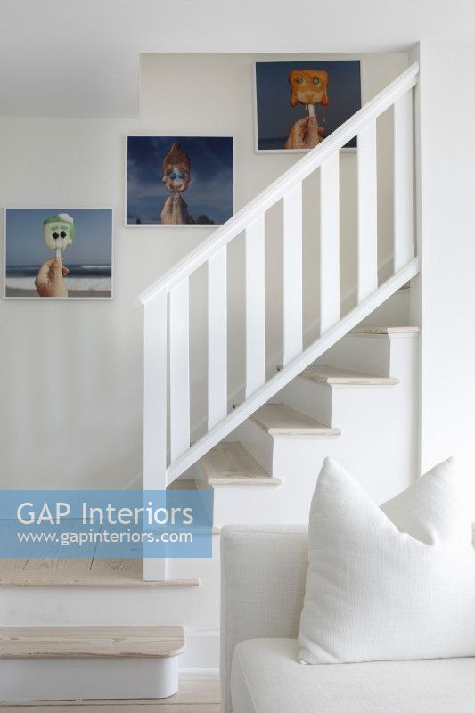 White stairway with photographs on wall