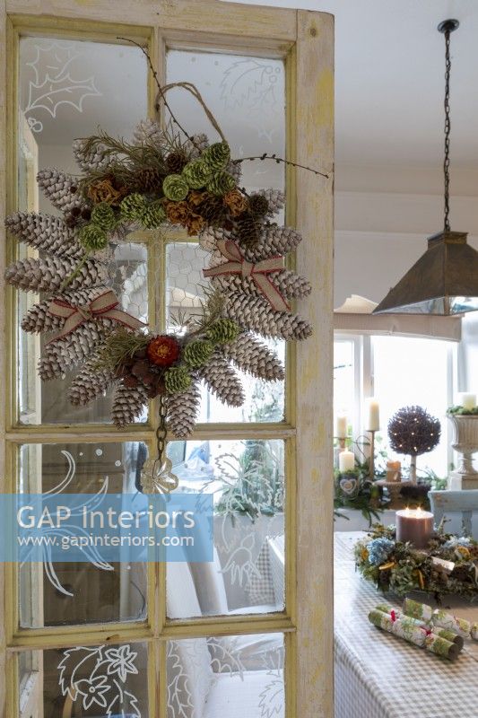 Indoor christmas wreath made with fir cones, in a cosy cottage at christmas