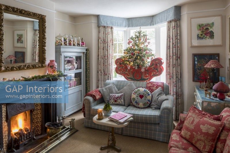 Sitting room with comfortable sofa and fireplace, decorated for christmas