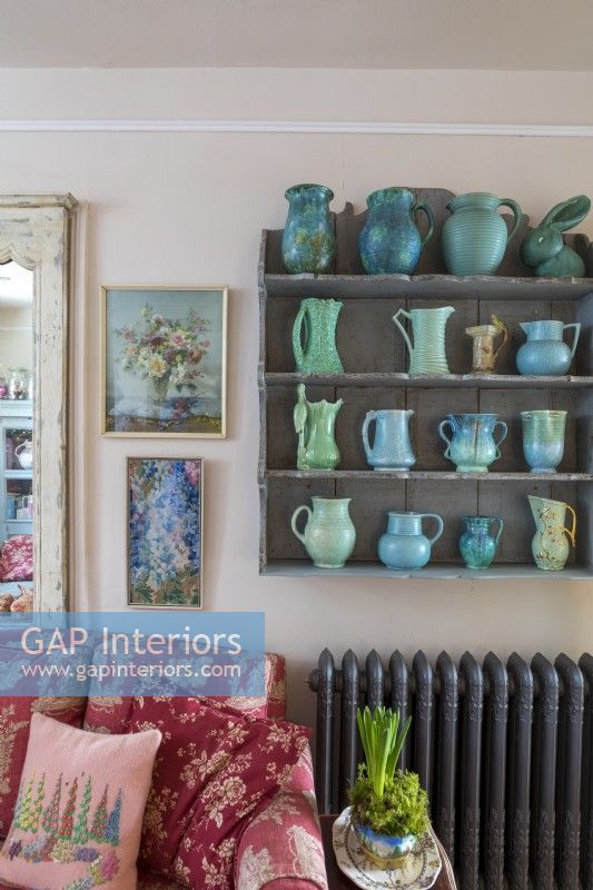 Simple shelving with blue and green vase collection, in comfortable country cottage