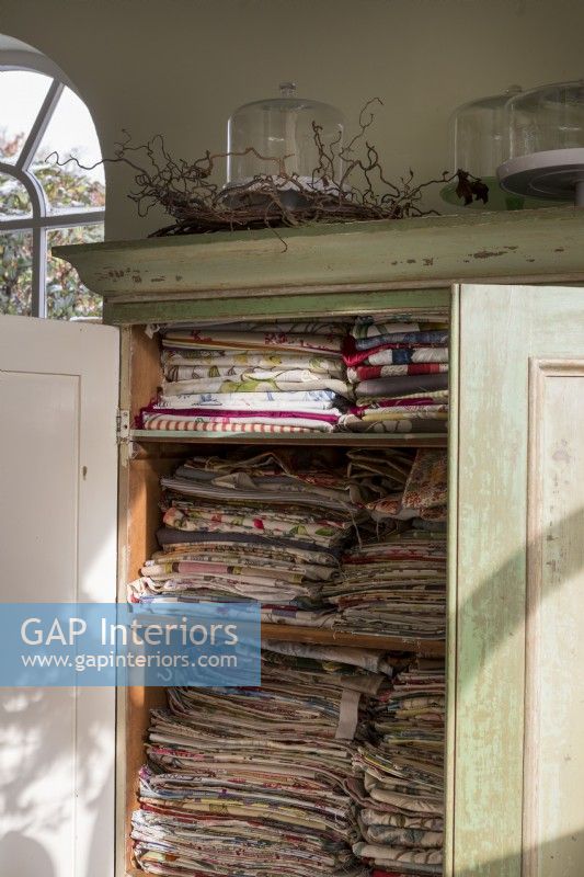 Linen cupboard packed with vintage materials and textiles