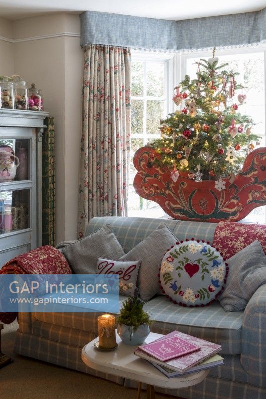 Sitting room with comfortable sofa and floral curtains, decorated for christmas