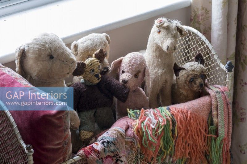 Collection of old stuffed toys in country bedroom