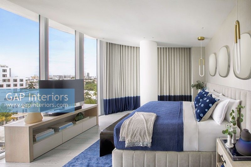 Modern blue and white bedroom with city view