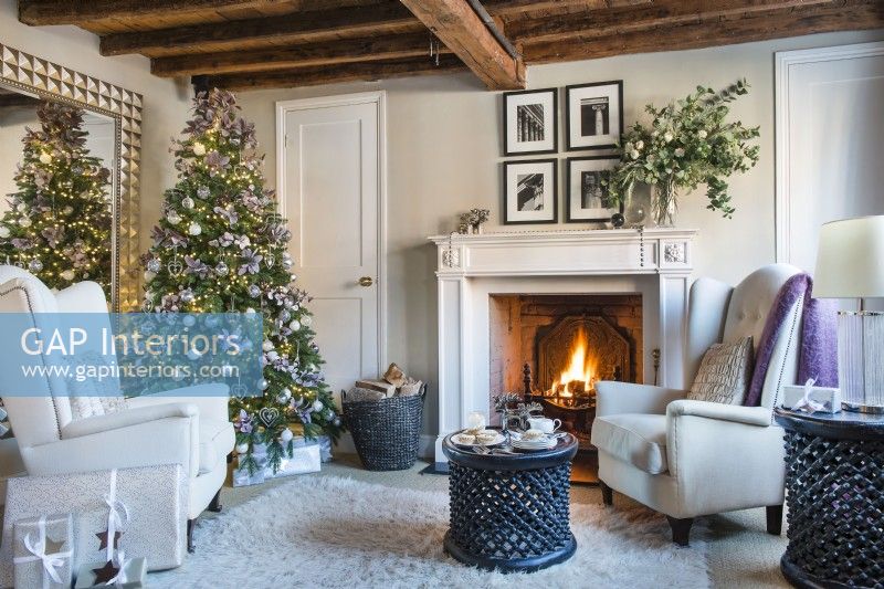 Lit fireplace in cosy classic living room decorated for Christmas 