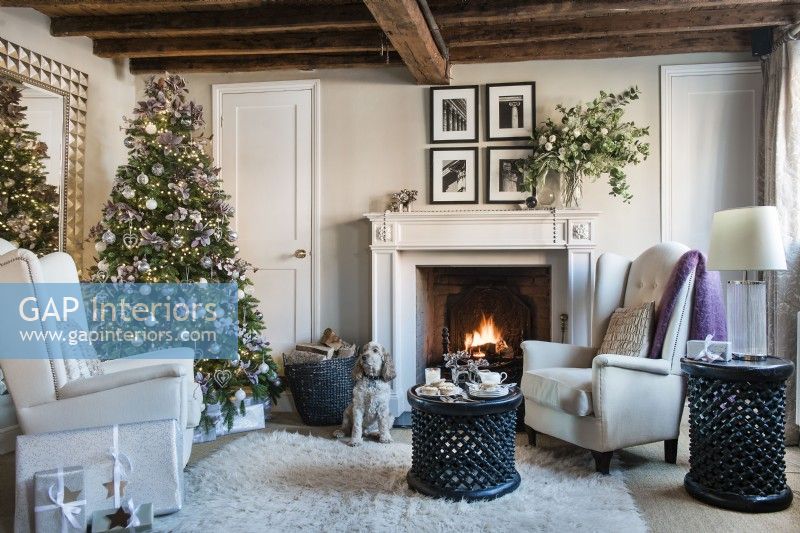 Pet dog next to fireplace in country living room decorated for Christmas