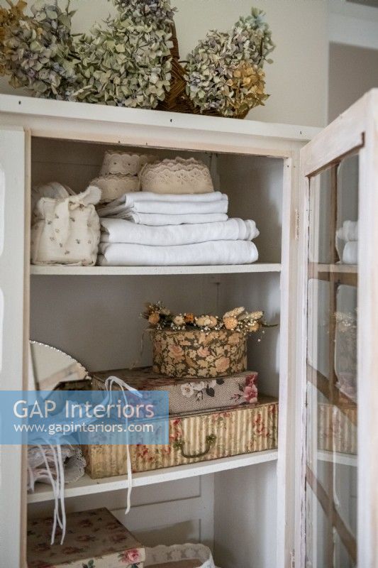 View into linen cupboard with vintage accessories