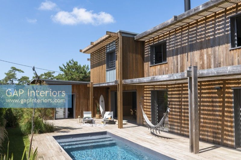 Swimming pool outside modern wooden house