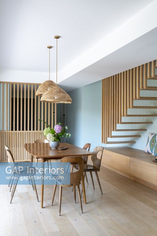 Modern wooden dining room with floating stair case