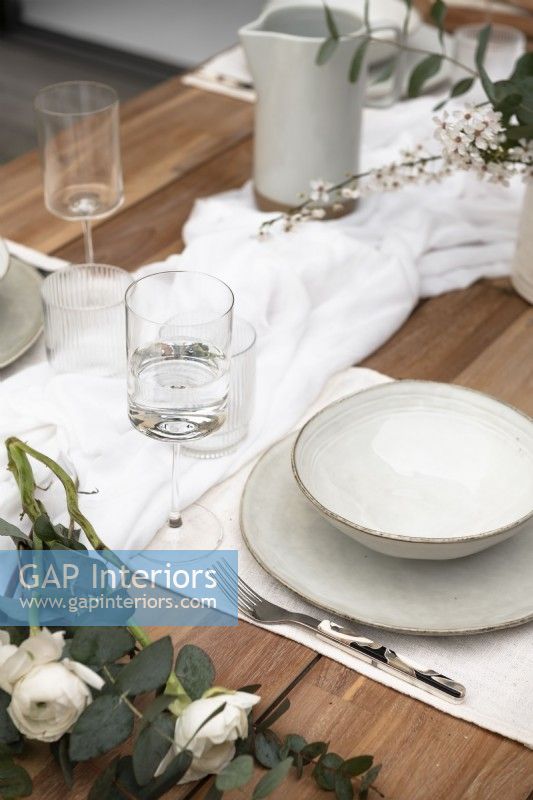 White crockery on wooden outdoor dining table - detail