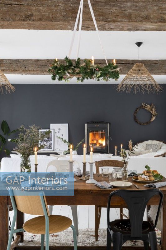 Lit fire and black feature wall in open plan living space at Christmas