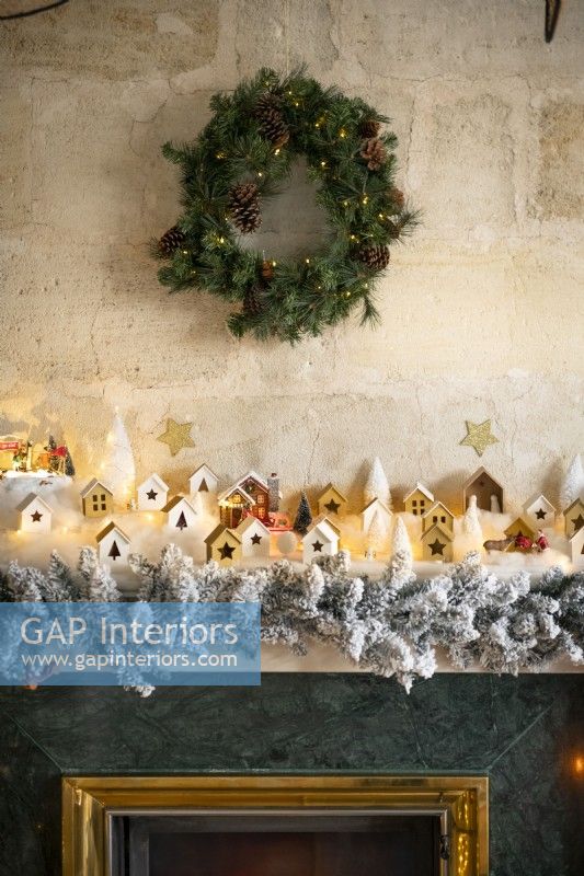 Wreath on stone wall above fireplace decorated for Christmas