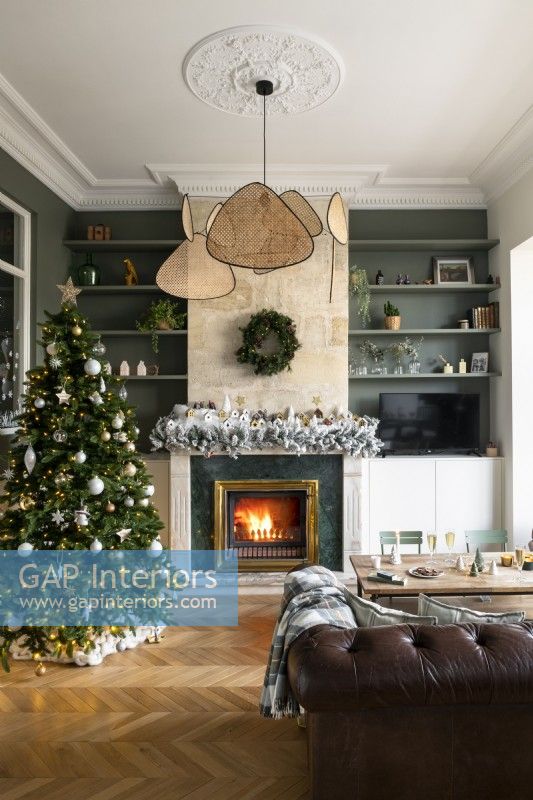 Lit fireplace in living room decorated for Christmas