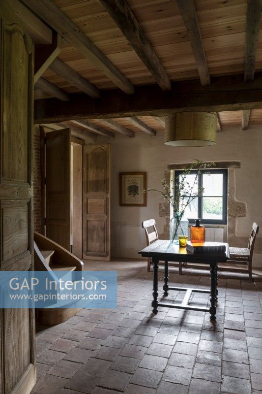 Table in country hallway with terracotta flooring 