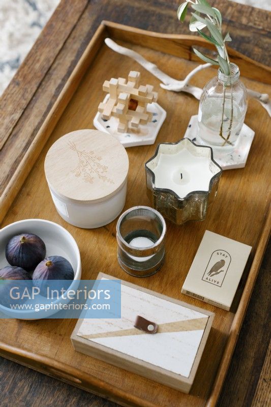 Detail of coffee table displaying candles and decorative items.