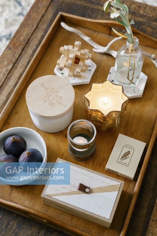 Detail of coffee table displaying candles and decorative items.