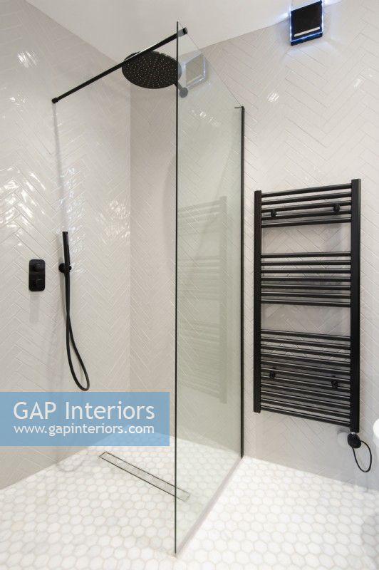 Modern walk in tiled shower with black towel radiator