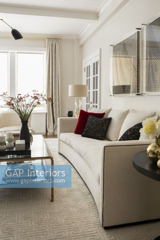 Modern white living room sofa and glass coffee table.