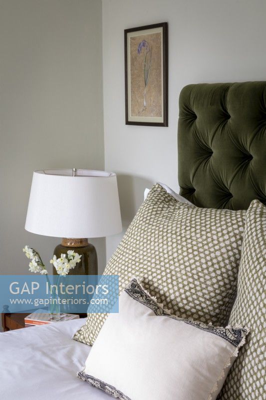 Detail of bed with green Button back upholstered headboard