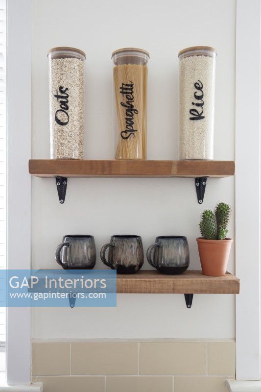 Modern food storage jars on wooden shelves in kitchen - detail 