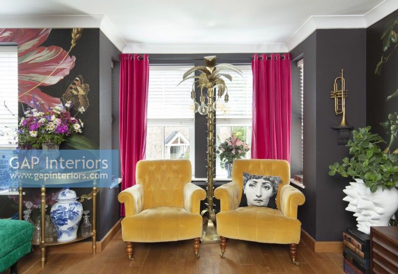 Two mustard armchairs in colourfully eclectic living room
