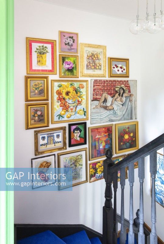 Display of eclectic artwork over staircase