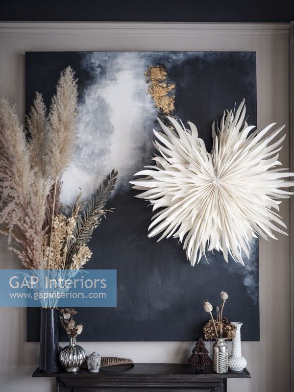Modern abstract painting with dried flowers on mantle
