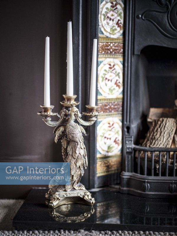 Ornate bird candelabra on fireplace