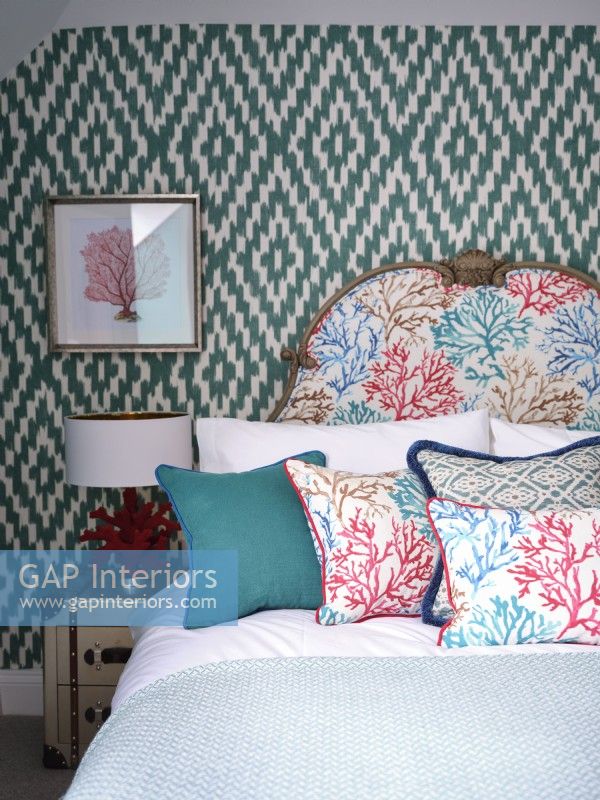 Colourful coastal inspired bedroom with upholstered headboard and wallpaper