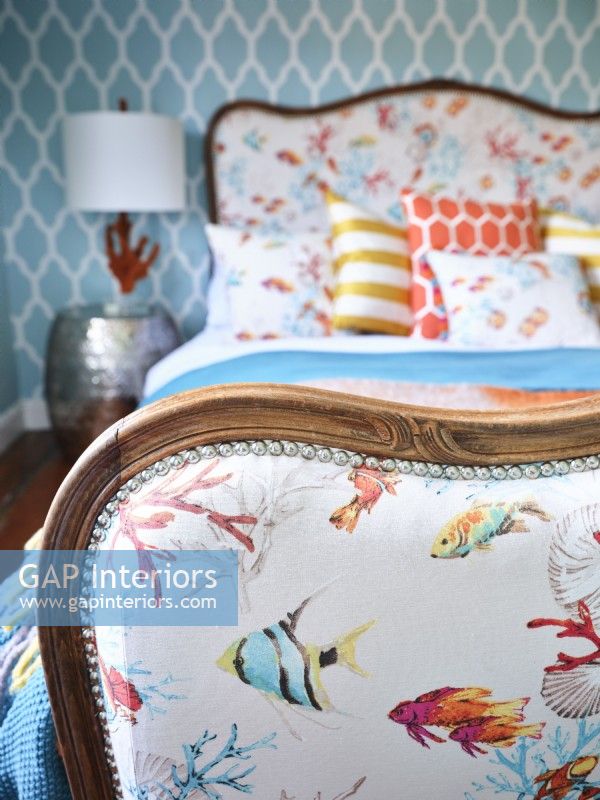 Colourful coastal themed upholstery on vintage bed