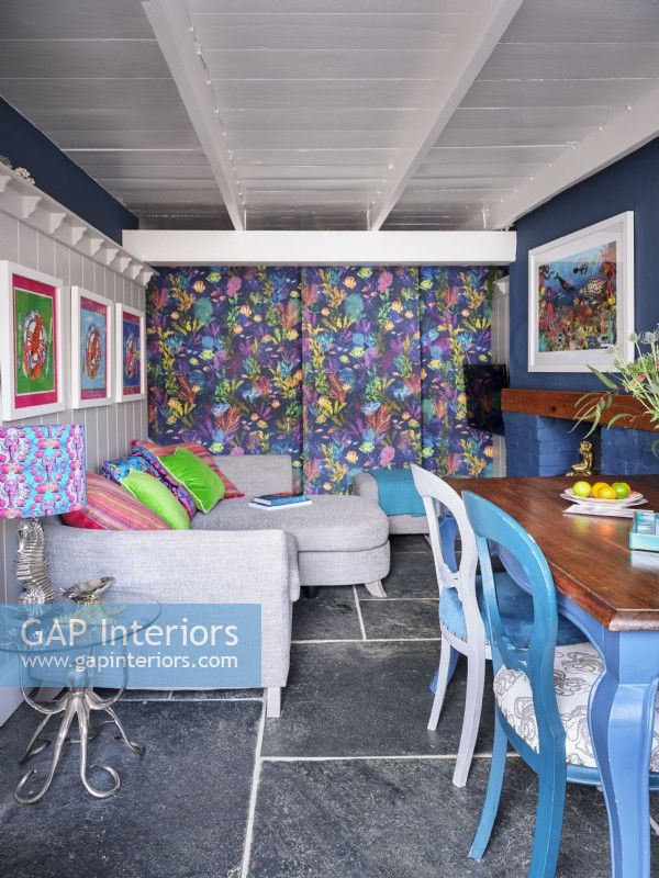 Colourful open plan dining room with patterned feature wall and marine artwork