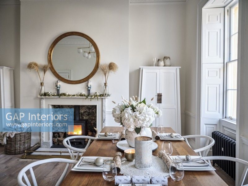 Neutral dining room featuring Christmas decorations and wood burning stove