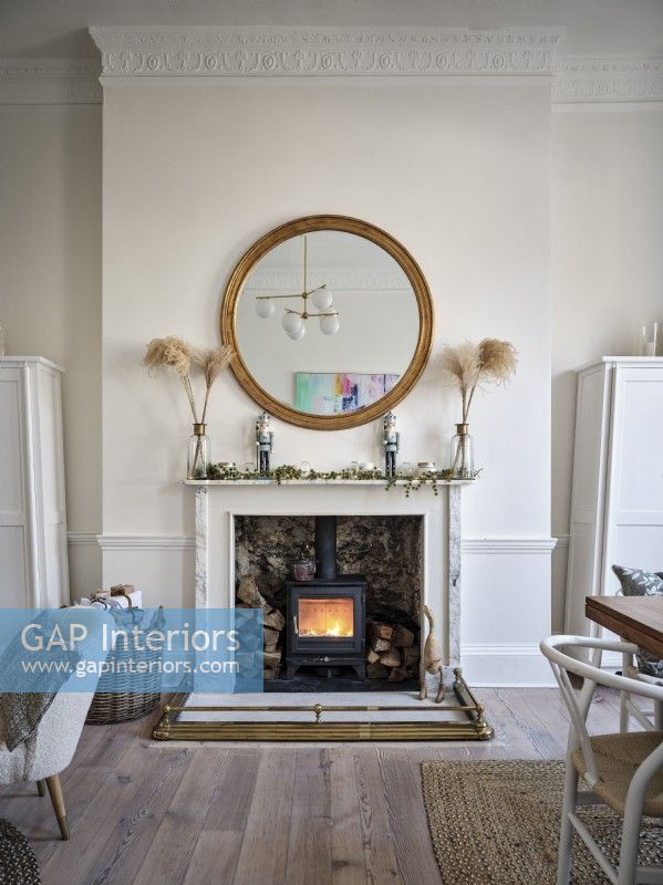 Wood burning stove, decorative mantel and circular mirror